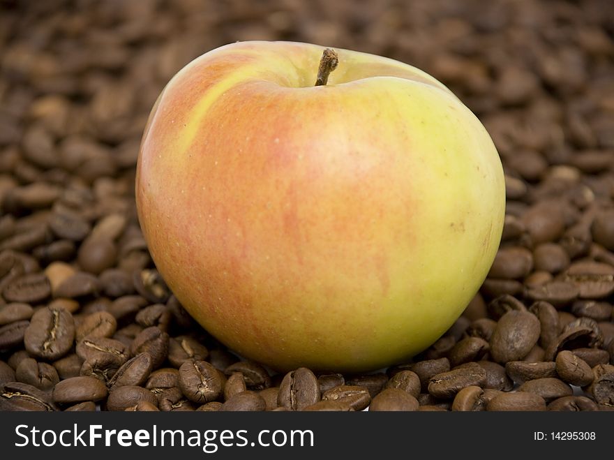 Fresh ripe apple lying on the coffee beans. Fresh ripe apple lying on the coffee beans