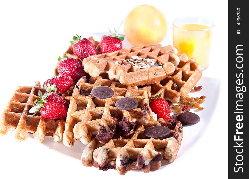 Fine decorated Waffles from integral wholegrain wiht strawberry , chocolate and dried grapes  on plate