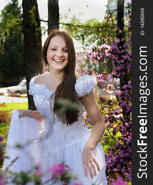 Portrait of the bride in a white dress with in  spring garden