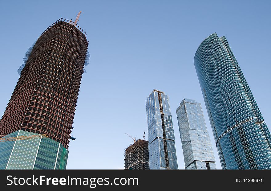 Skyscrapers with scaffolding over clear blue sky. Skyscrapers with scaffolding over clear blue sky