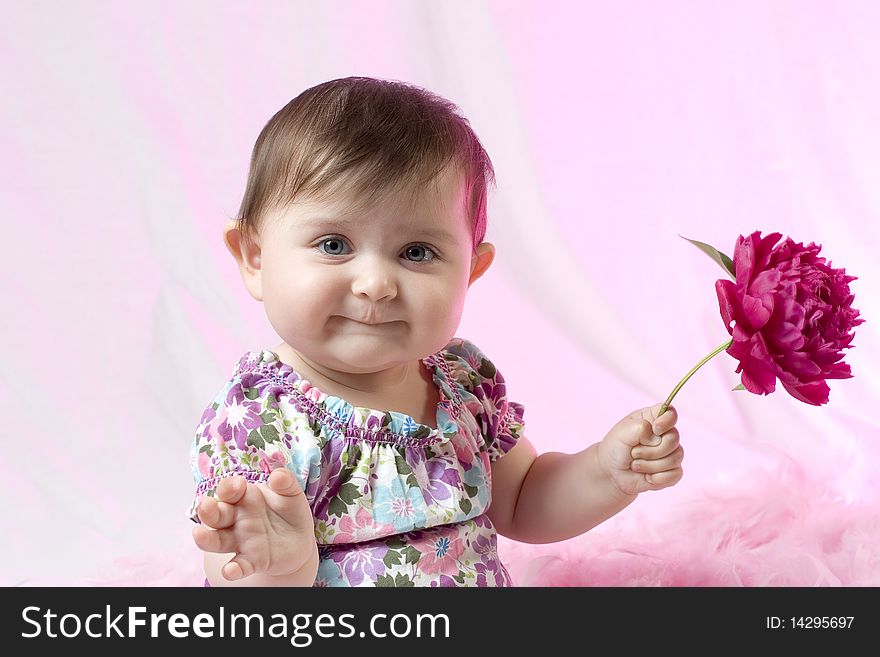 Baby girl with peony flower on pink background. Baby girl with peony flower on pink background