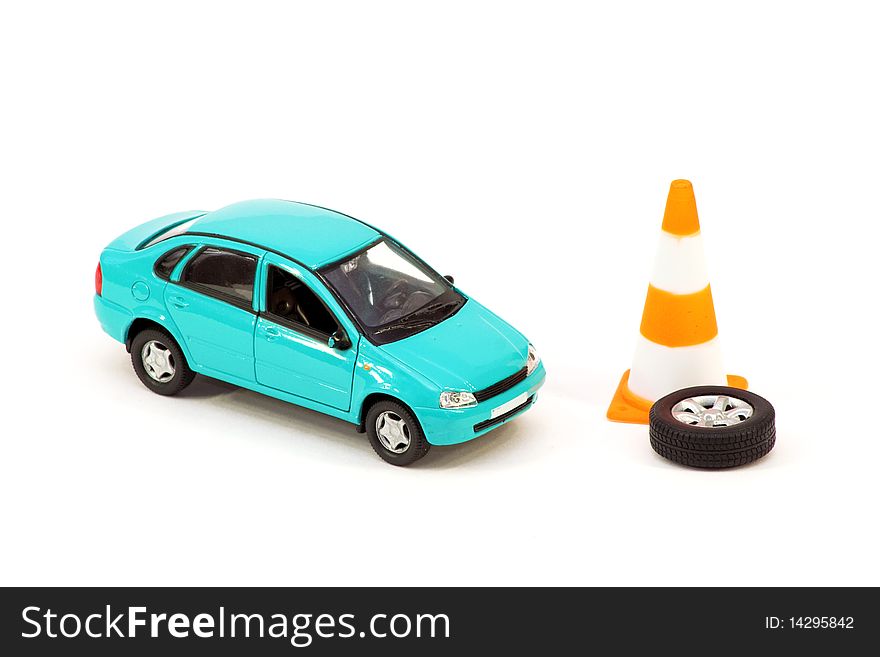 The car toy, the cone and the emergency spare wheel on a white background. Concept. The car toy, the cone and the emergency spare wheel on a white background. Concept