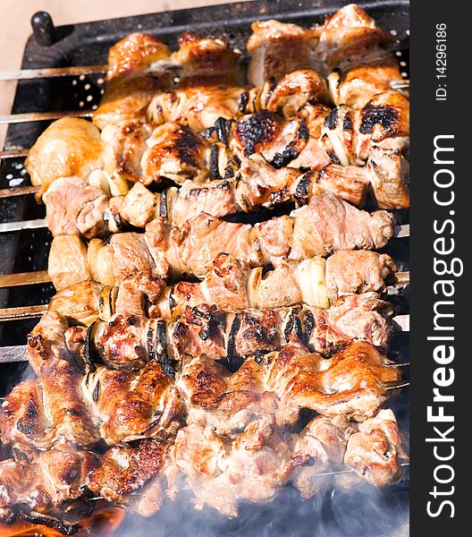 Big pieces of marinated pork and chicken on barbecue. Big pieces of marinated pork and chicken on barbecue