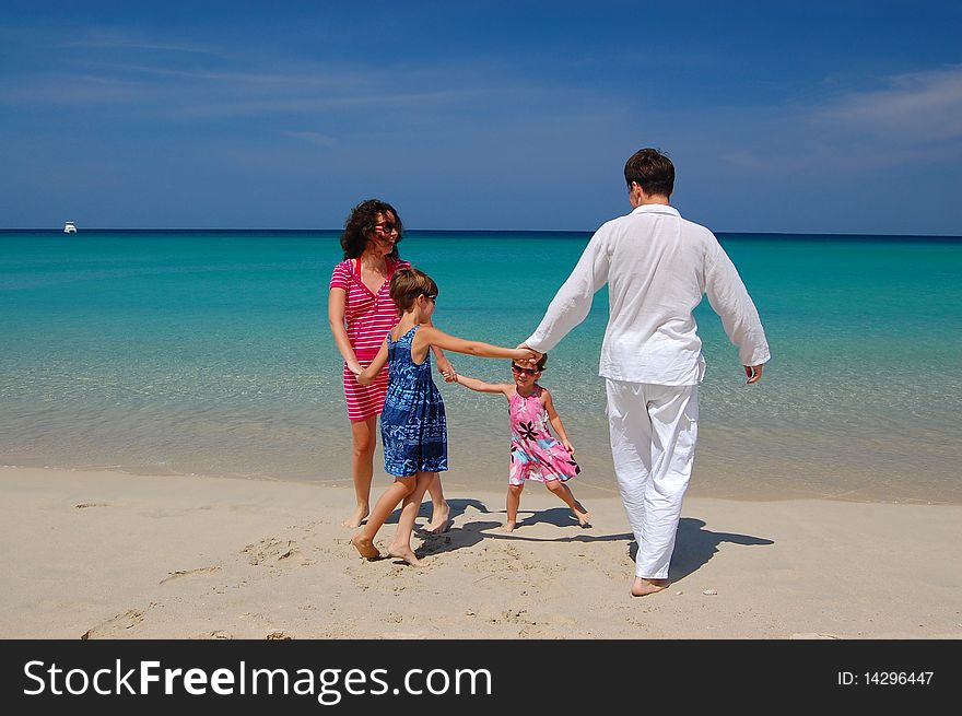 Parents playing with their children on the tropical beach. Parents playing with their children on the tropical beach