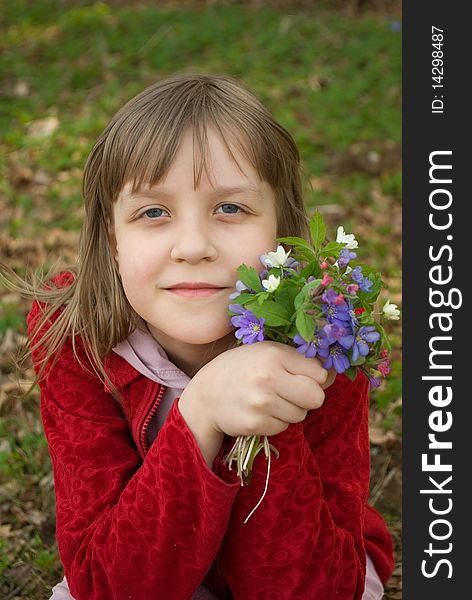 Portrait of a beautiful smiling girl of school age with a bouqete of snowdrops. Portrait of a beautiful smiling girl of school age with a bouqete of snowdrops