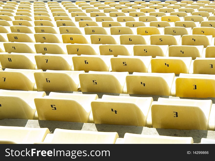 Rows of yellow chairs on a soccer stadium