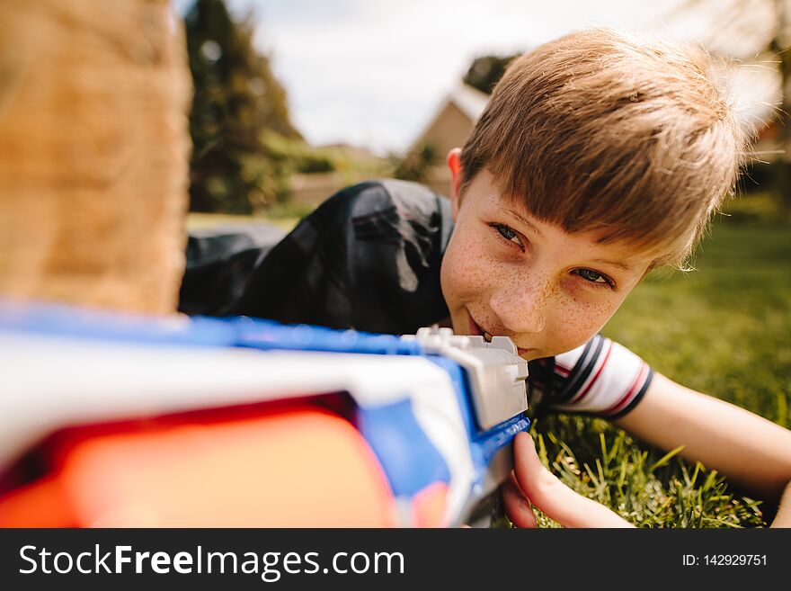 Cute boy playing with toy gun in playground