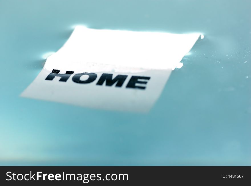 Card floating on water surface with printed word: HOME. Card floating on water surface with printed word: HOME
