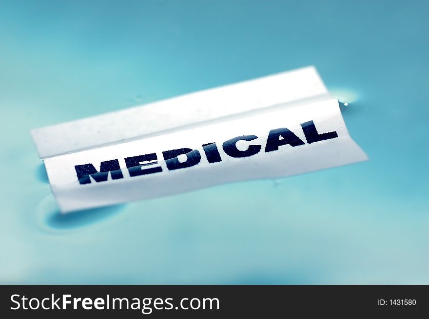 Card floating on water surface with printed word: MEDICAL. Card floating on water surface with printed word: MEDICAL