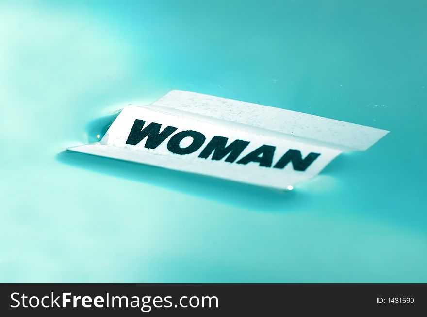 Card floating on water surface with printed word: WOMAN. Card floating on water surface with printed word: WOMAN