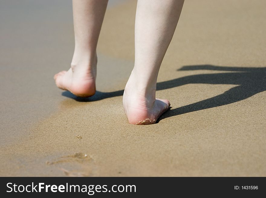 A woman's legs walking in the sand. A woman's legs walking in the sand