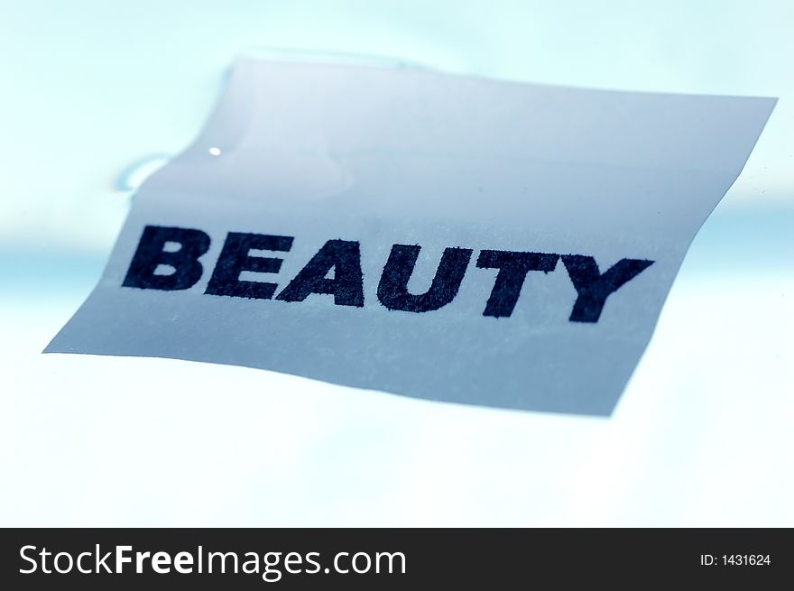 Card floating on water surface with printed word: BEAUTY. Card floating on water surface with printed word: BEAUTY