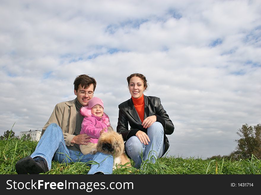 Family with baby and dog on grass
