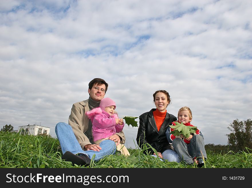 Family of four on autumn grass