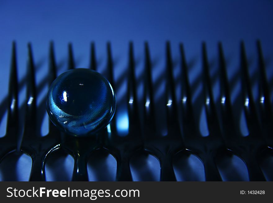 Artistic view of a glass sphere on a line of forks. Artistic view of a glass sphere on a line of forks