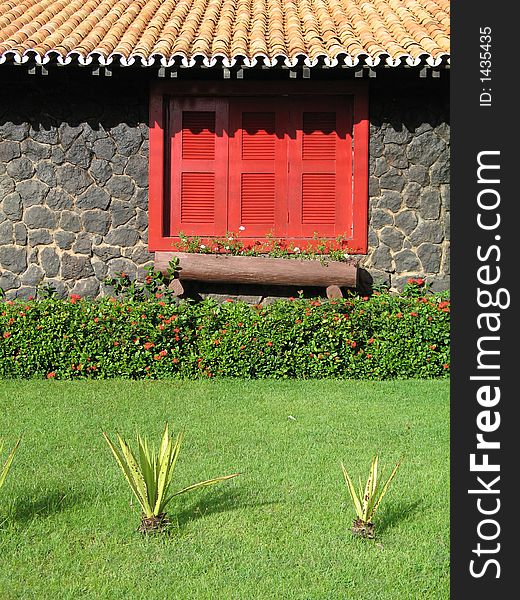 House of field with red window and plants