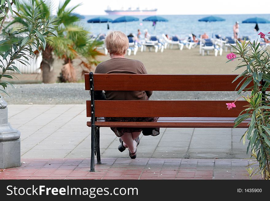An old woman looking at the beach. An old woman looking at the beach