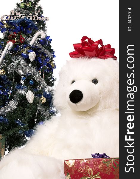 A christmas tree with wrapped presents around the base and a huge stuffed bear. A christmas tree with wrapped presents around the base and a huge stuffed bear