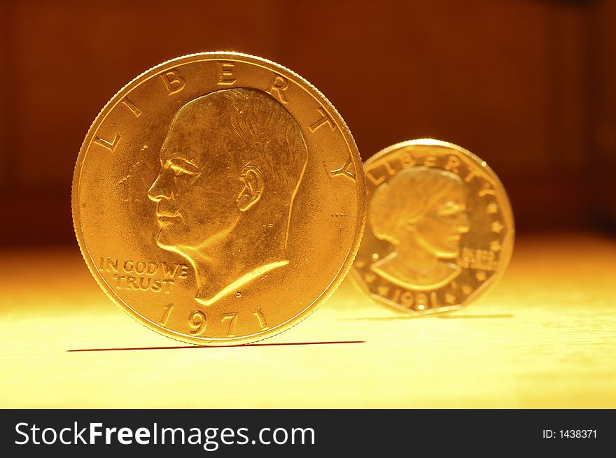 Some golden coins in a yellow light. Some golden coins in a yellow light.