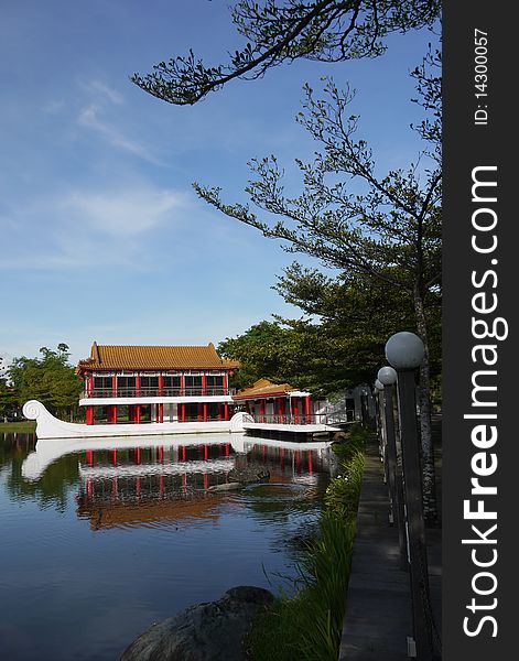 A beautiful stone boat with teahouse pavilion built above its deck sits on the lagoon at Chinese Garden