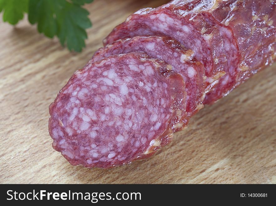 Close up of sliced salami on wooden board