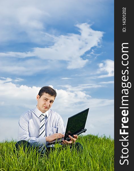 Businessman working in a meadow with laptop. Businessman working in a meadow with laptop