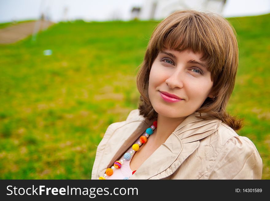 Woman's portrait with green grass on background. Woman's portrait with green grass on background