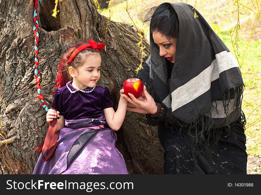 Stepmother gives poisoned apple give to snow white little girl. Stepmother gives poisoned apple give to snow white little girl