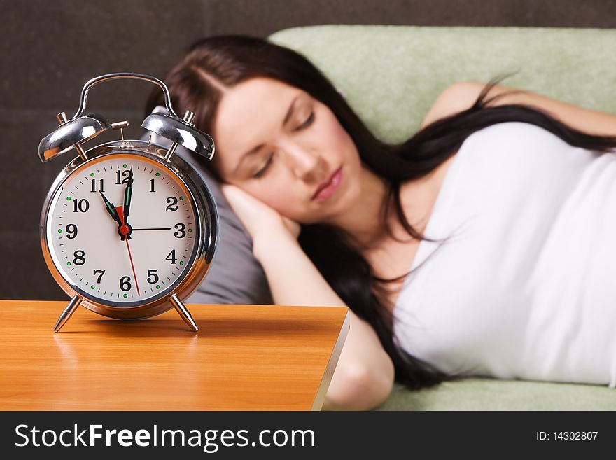 Vintage alarm clock, with beautiful young woman sleeping in the background. Vintage alarm clock, with beautiful young woman sleeping in the background