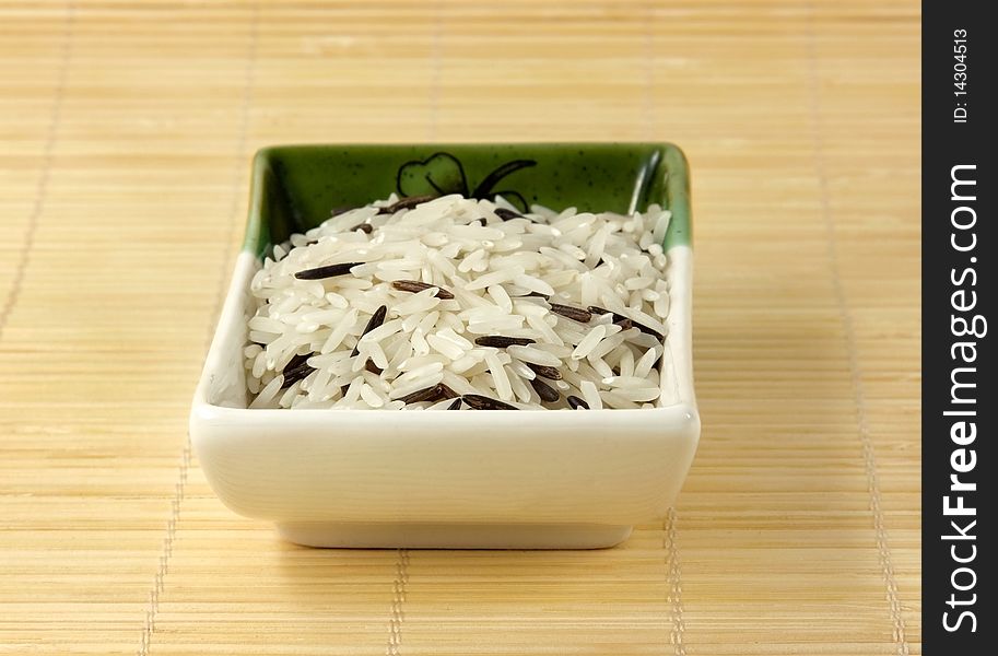 A bowl of mixed rice on a bamboo mat. A bowl of mixed rice on a bamboo mat