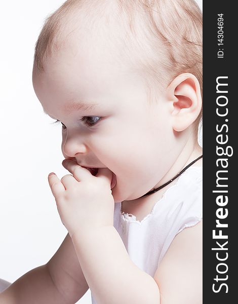 Studio portrait of cute baby holding finger at mouth