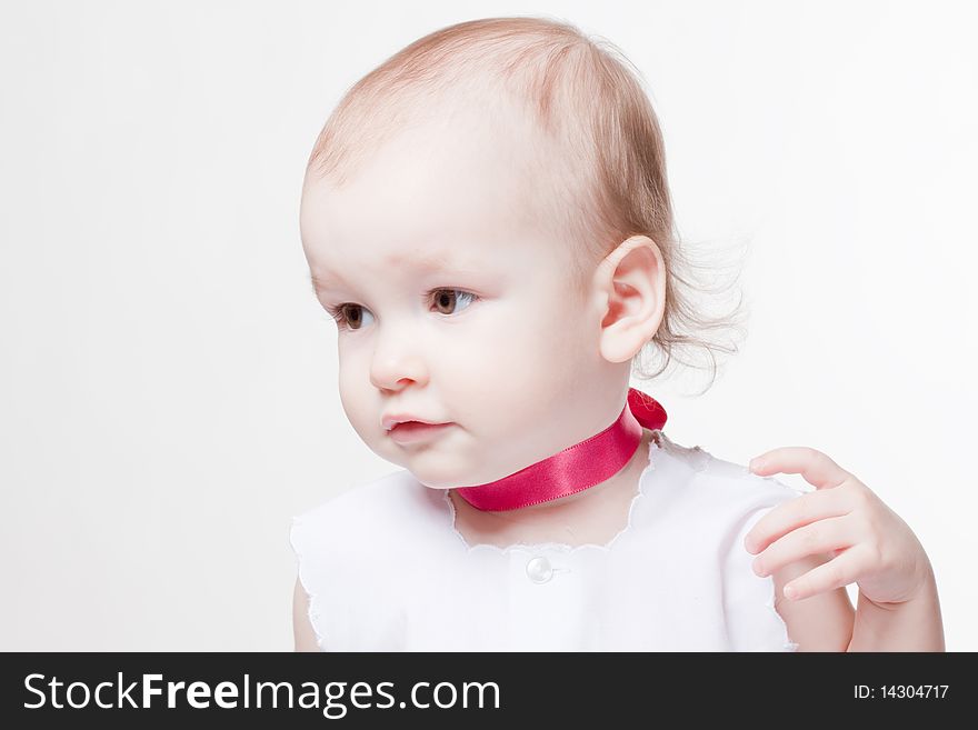 Little cute baby in pink silk necklace and white dress