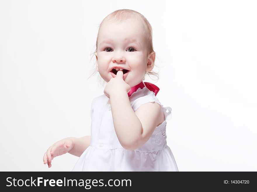 Closeup portrait of a cute baby with finger at smiling mouth