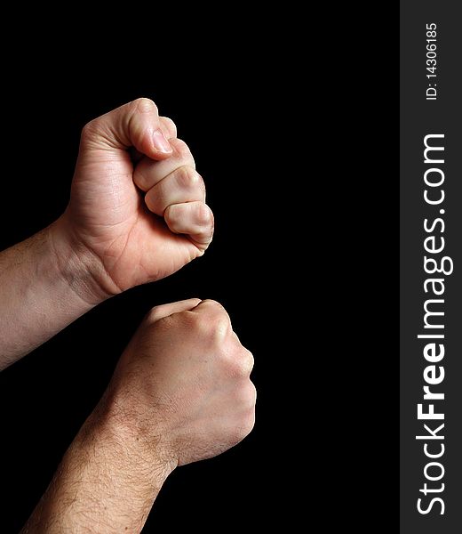 Two men's hands with clenched fists. Present position to start a fight. On a black background.