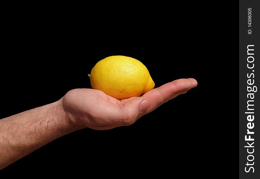 Yellow lemon laid on men's outstretched hand. On a black background. Yellow lemon laid on men's outstretched hand. On a black background.