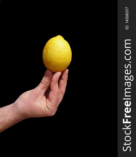 Yellow lemon which holds the men's hand. On a black background.