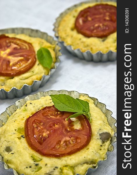 Salty tartelettes with cheese and tomatoes.