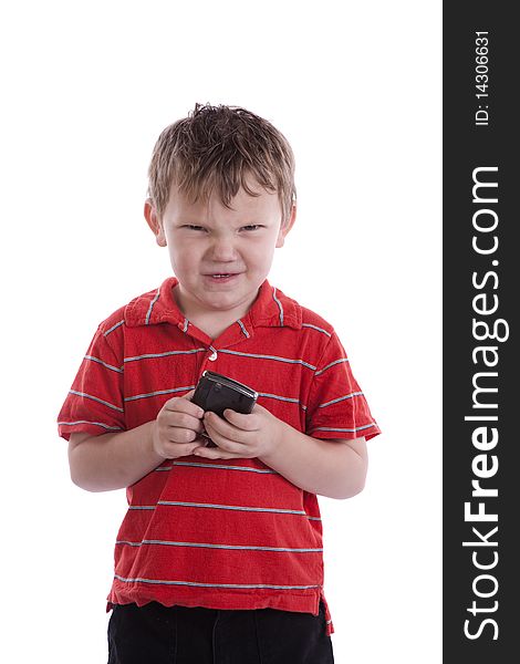 A young boy has a cell phone with a mad expression on his face. A young boy has a cell phone with a mad expression on his face.