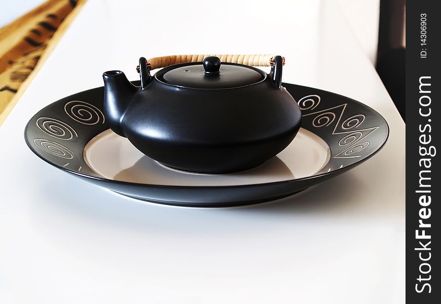 Black ceramic teapot on a tray. Black ceramic teapot on a tray