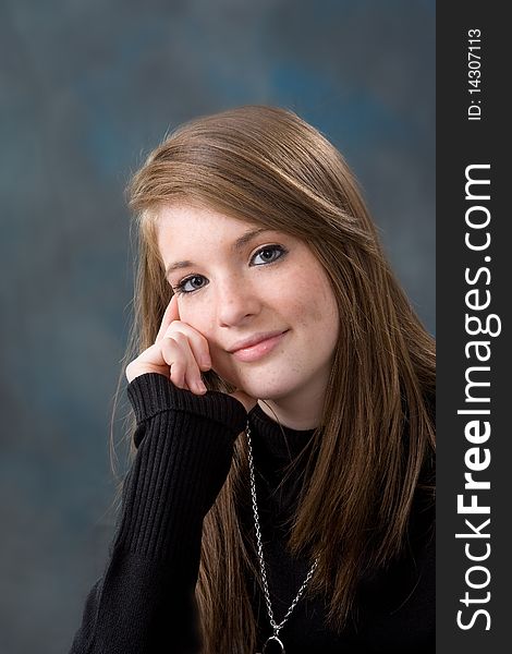 Portrait of pretty young teen age girl on blue background.