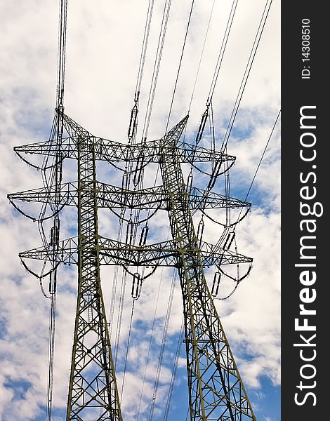 High voltage power line pole over blue sky with white clouds. High voltage power line pole over blue sky with white clouds.