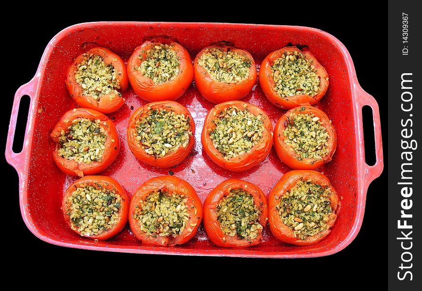 Stuffed peppers  with rice,  cinnabar and herbs in a red baking pan