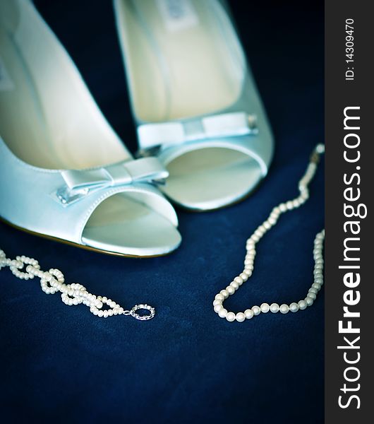 Bridal accessories blue shoes and pearl necklace and bracelet on blue velvet. Bridal accessories blue shoes and pearl necklace and bracelet on blue velvet.