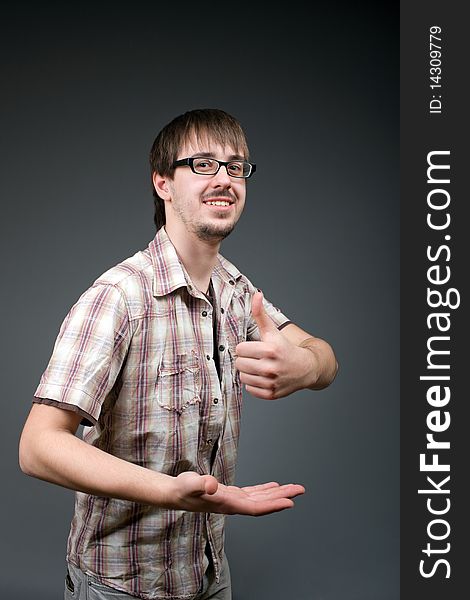 Young man with class gesture on grey