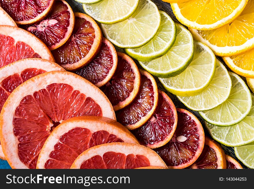 Healthy eating concept. Pattern with fresh slices of different Citrus fruit - yellow and red orange, lime, lemon and grapefruit. Flat lay. Healthy eating concept. Pattern with fresh slices of different Citrus fruit - yellow and red orange, lime, lemon and grapefruit. Flat lay
