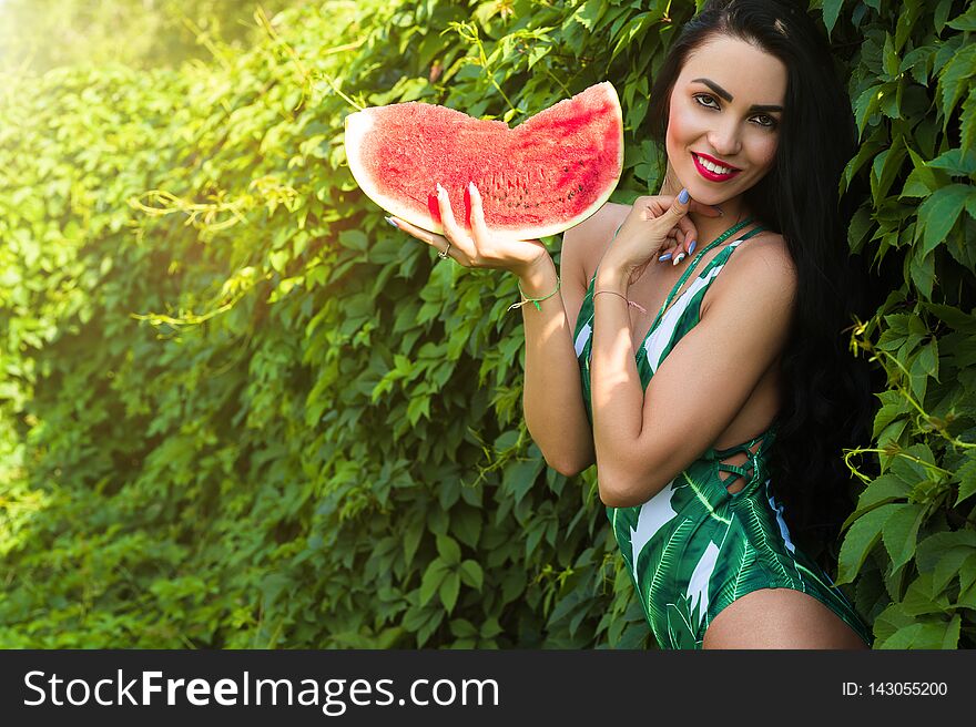 Smiling woman with slice watermelon in summer outdoor with swimsuit