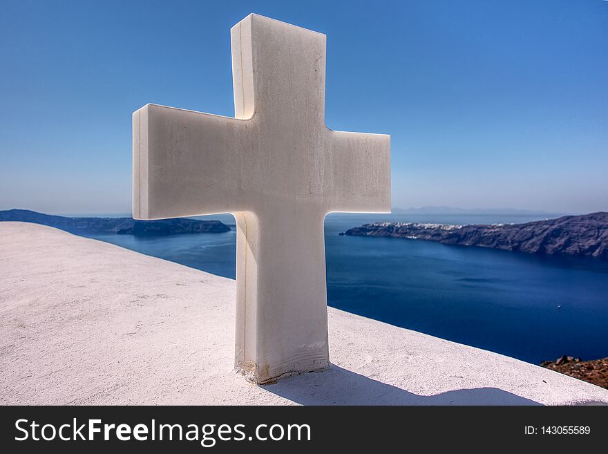 This cross is on a church that rests behind a mountain in Santorini. This cross is on a church that rests behind a mountain in Santorini
