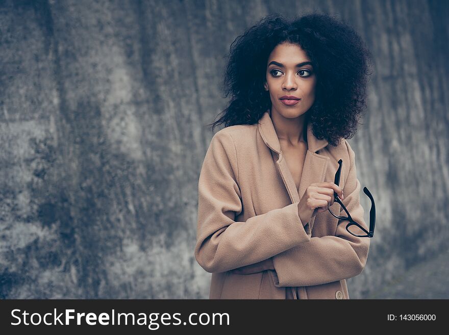 Portrait of minded nice cute confident gorgeous magnificent sweet lovely adorable pretty well-groomed feminine curly-haired lady in warm fall cosy beige clothes eyewear eyeglasses outside.