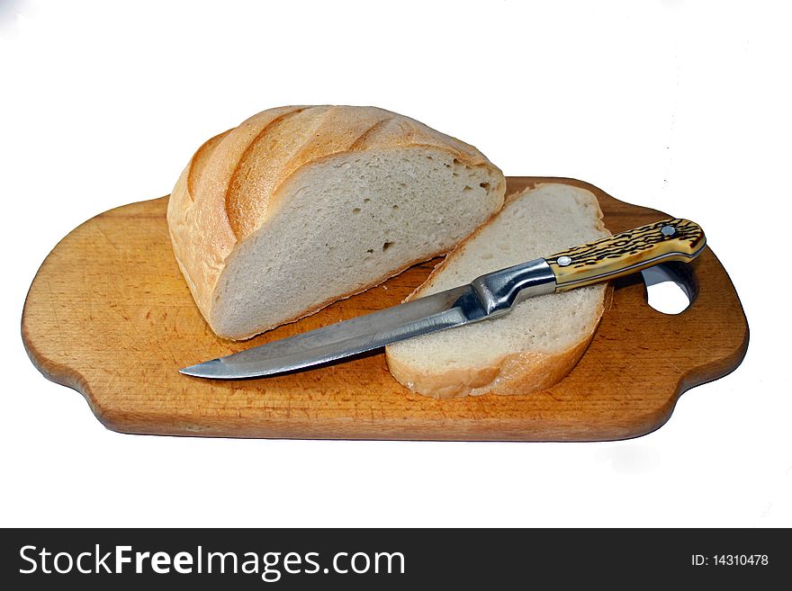White bread, a symbol of fullness, cutting off one piece, cutting board, sharp knife,
fresh bread