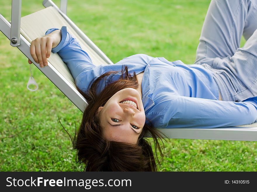 Smiling Pretty Girl Lying On A Deckchair